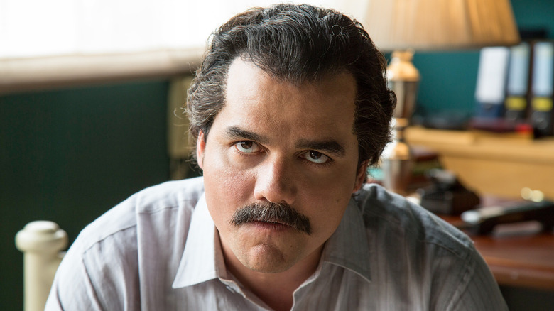 Wagner Moura as Pablo Escobar sitting and looking scary on Narcos