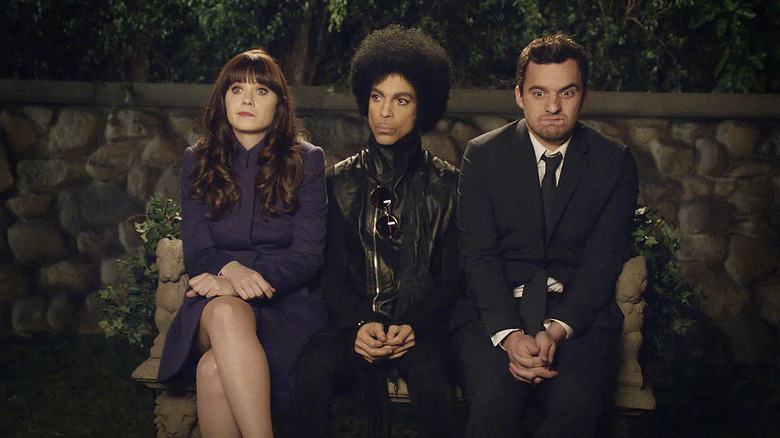 Prince sitting between a shocked Jess and Nick on New Girl