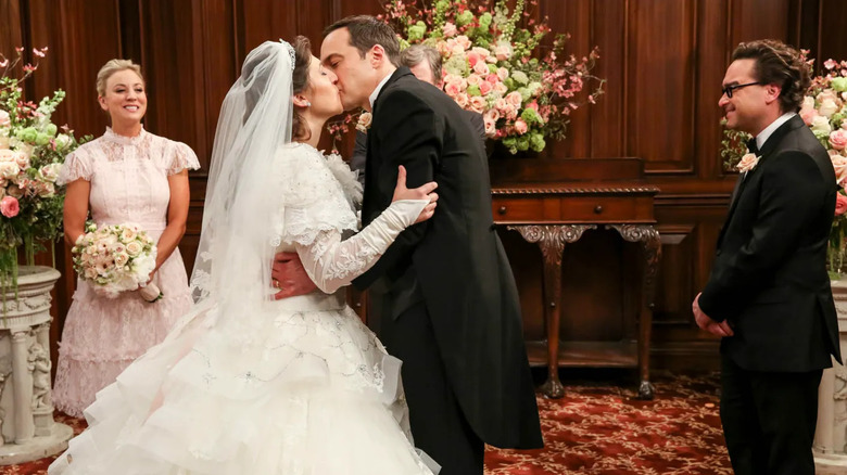 Amy and Sheldon kissing at their wedding with Penny and Leonard at their side in The Big Bang Theory