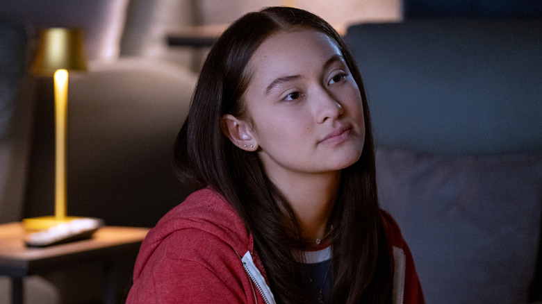 Belly in a red hoodie looking at someone pensively in The Summer I Turned Pretty
