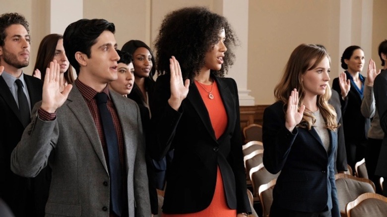 Characters standing in court room with right arm raised in For the People