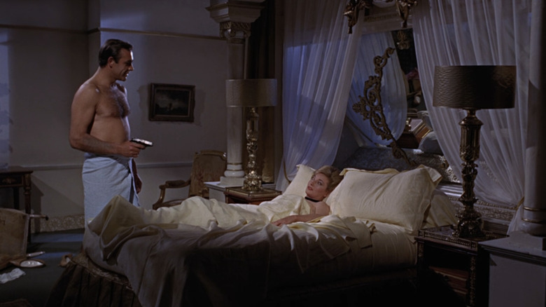 Sean Connery's James Bond points a pistol at Daniela Bianchi's Tatiana Romanova as she lays in his bed in From Russia with Love