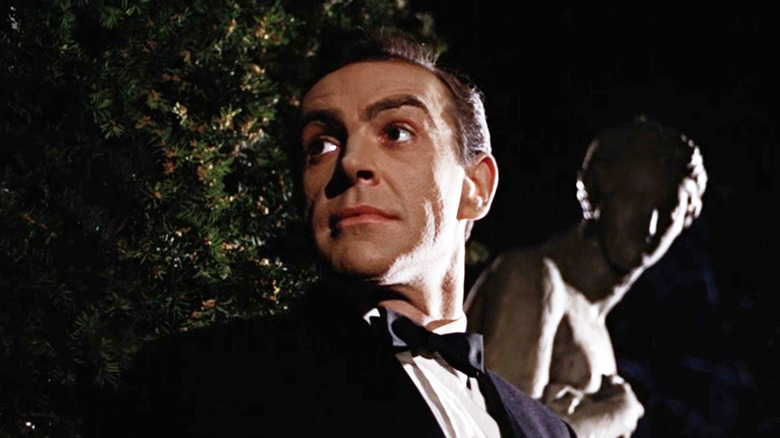Sean Connery's James Bond looks off to his right with a statue visible in the background in From Russia with Love
