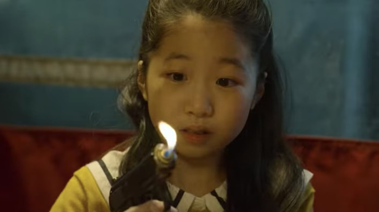 Ga-yeong holding a gun lighter on Squid Game