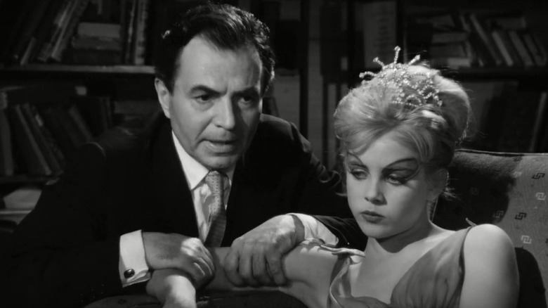 Humbert (James Mason) grabs the arm of a reclining Dolores (Sue Lyon) in Lolita (1962)