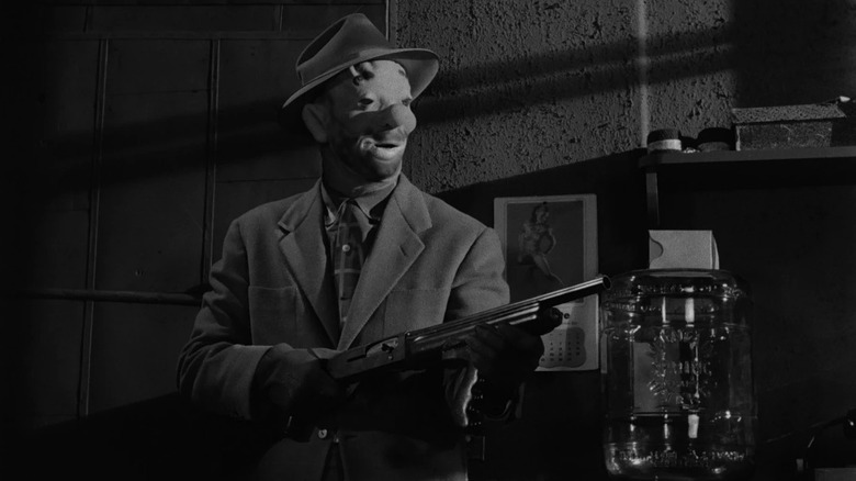 A masked Johnny Clay (Sterling Hayden) points a shotgun in The Killing (1956)