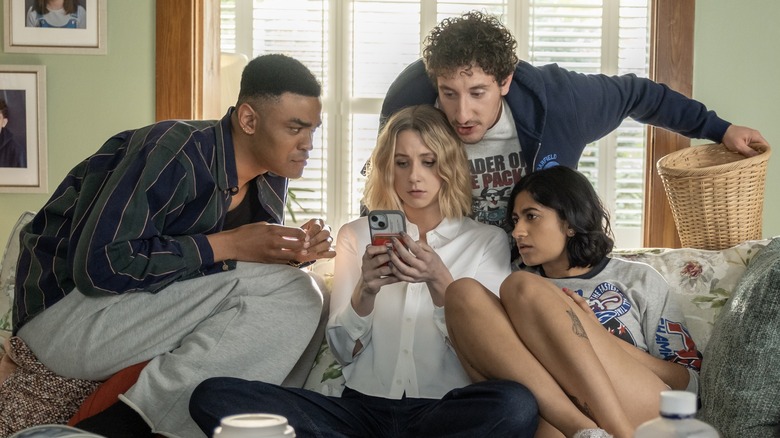The cast of Adults looking at a cell phone
