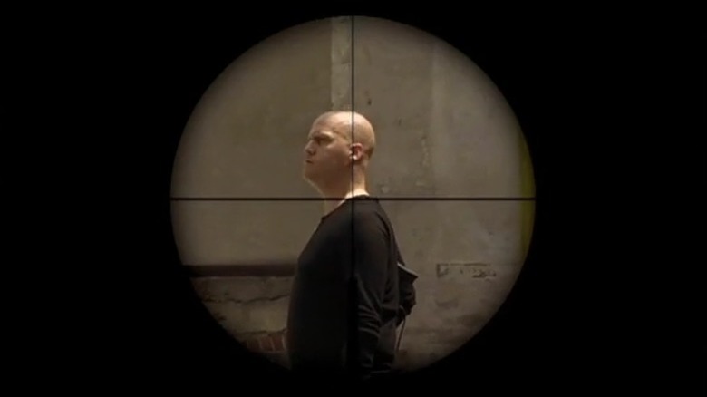Bald man in rifle scope