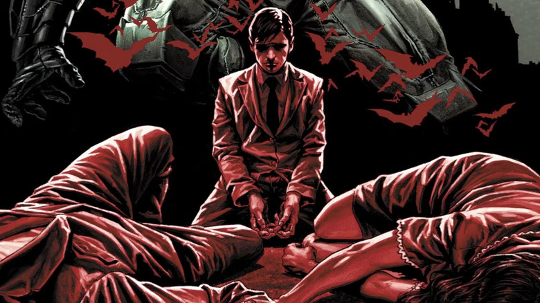 Bruce Wayne kneeling before his murdered parents, bathed in red light