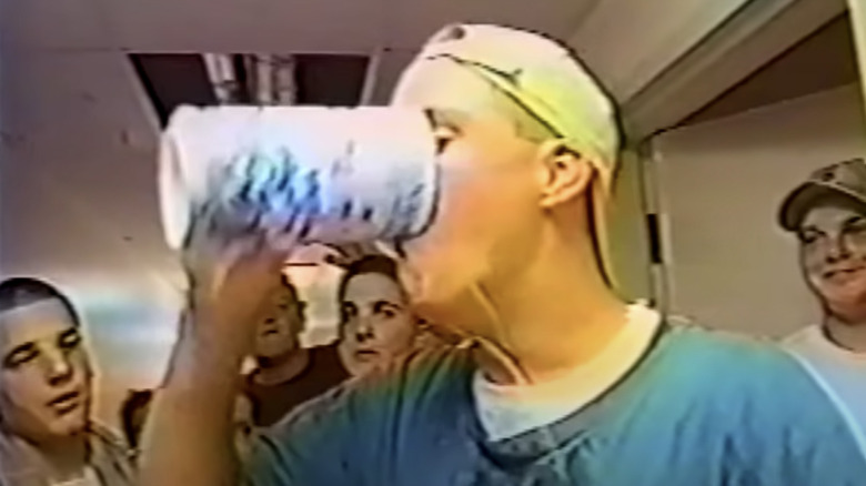 Man in hat guzzling beer in "Frat House"
