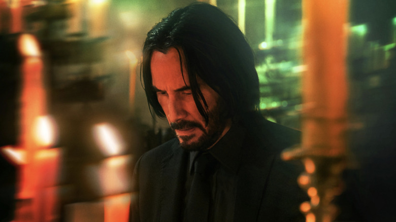 John Wick Chapter 4 -- Keanu Reeves as John Wick surrounded by candles