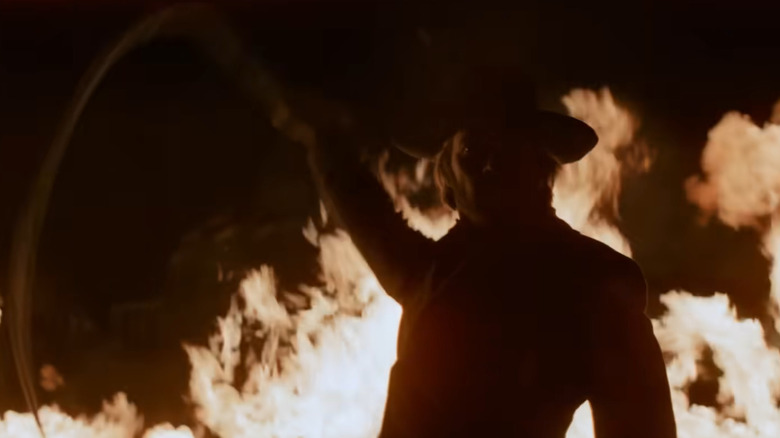 The Stranger brandishing a whip against a fire in High Plains Drifter