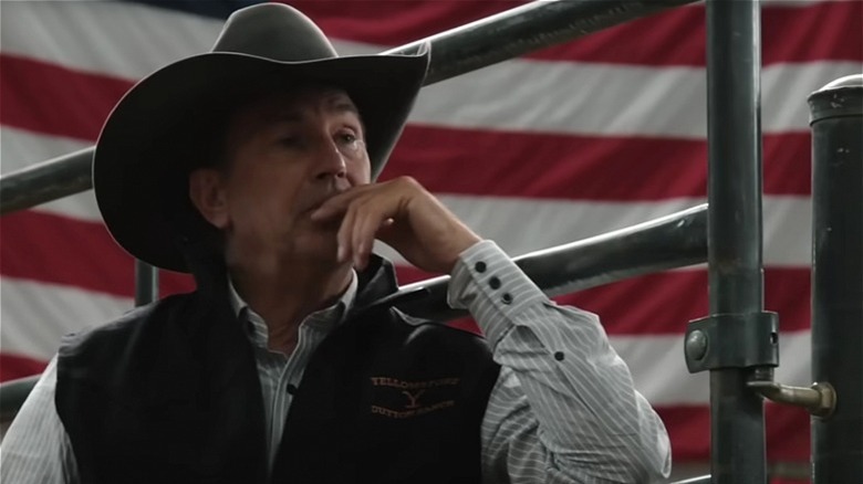 John Dutton in front of a flag