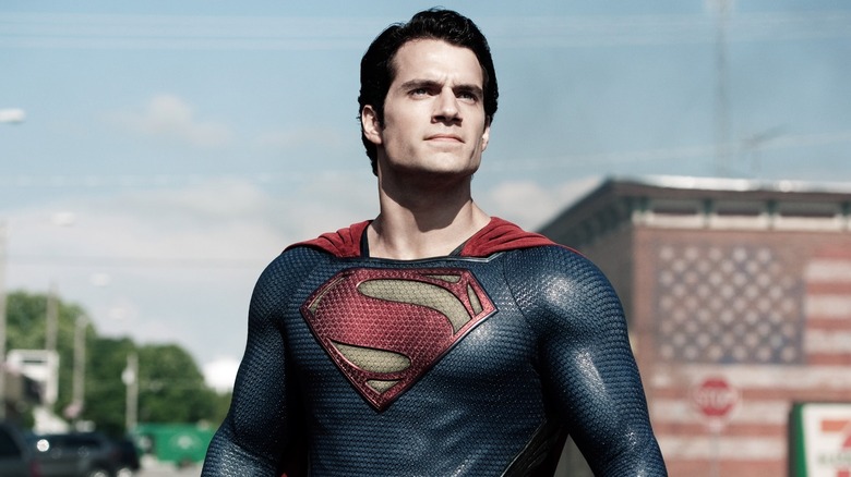 Henry Cavill as Superman stood in front of the American flag in Man of Steel