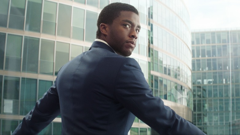 Chadwick Boseman with his back toward the camera looking behind him
