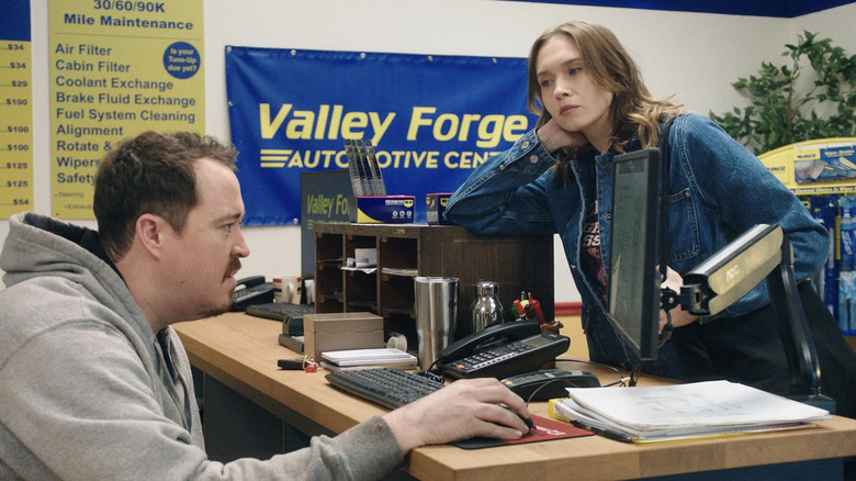 Veronika Slowikowska as Kelly looks at Shane Gillis as Shane behind the desk in Netflix's Tires