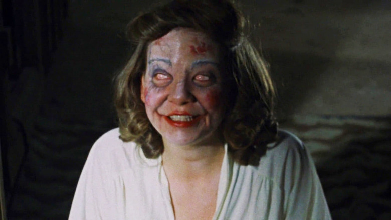 A possessed Cheryl smiling in The Evil Dead