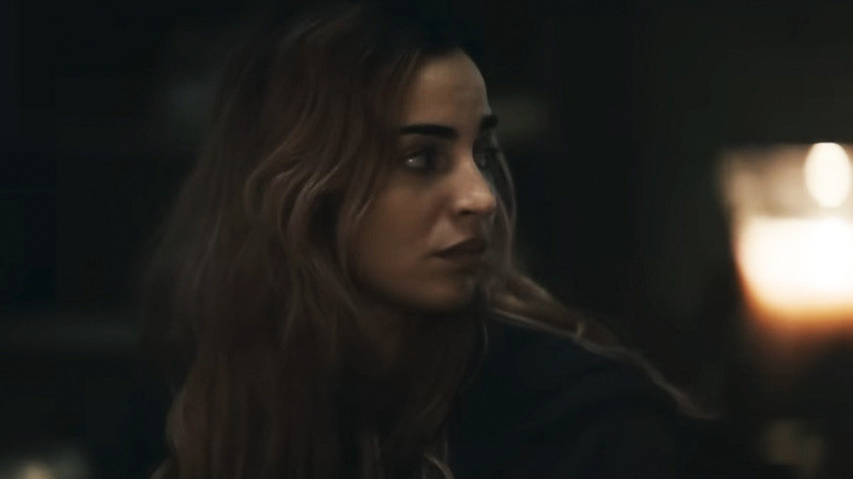 Alice looks off to the side at something off camera in Evil Dead Burn