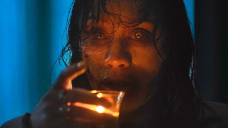 Thya gets ready to enjoy a candle wax cocktail in Evil Dead Burn