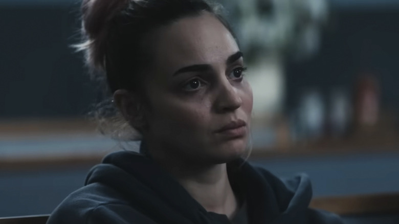 A hoodie-clad Alice sits in the pew at a funeral in Evil Dead Burn