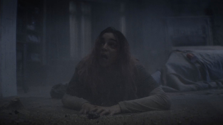 ஈவில் டெட் பர்னில் ஒரு பெண் தரையில் ஊர்ந்து செல்கிறாள்