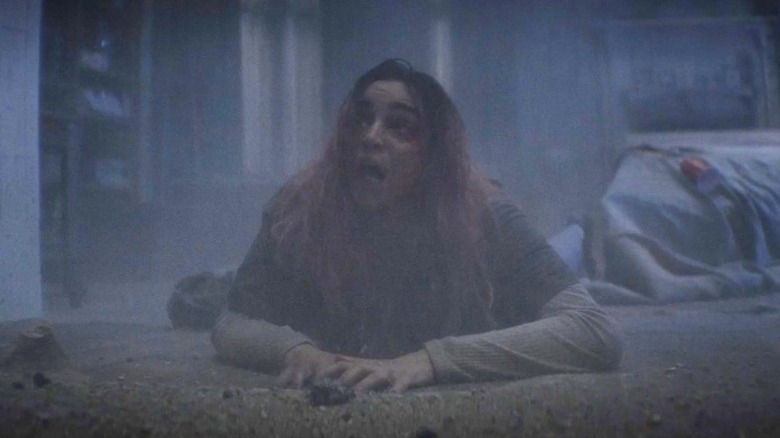 A woman crawls on the floor in Evil Dead Burn