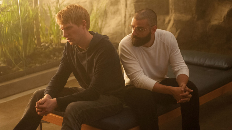 Caleb (Domhnall Gleeson) and Nathan (Oscar Isaac) contemplate their ethical choices while seated on a bench in Ex Machina