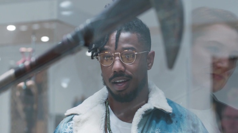 Erik Killmonger (Michael B Jordan) looks at a Wakandan artifact in a museum during Black Panther.