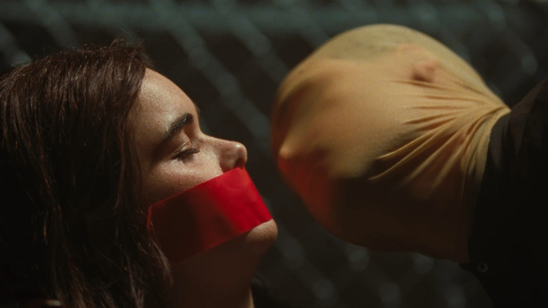 A captive Margot is menaced by a masked Arthur in Faces of Death