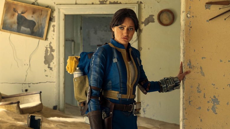 Ella Purnell standing in an abandoned house in Fallout