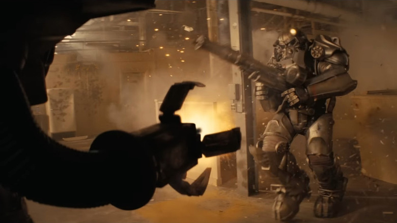 Aaron Moten as Maximus in his power suit attacking Jesse Burch as the voice of Victor in Fallout