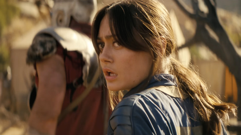 Lucy looking alarmed by the members of Caesar's Legion in Fallout