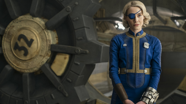 Annabel O'Hagan as Stephanie Harper standing in front of a vault door in Fallout season 2