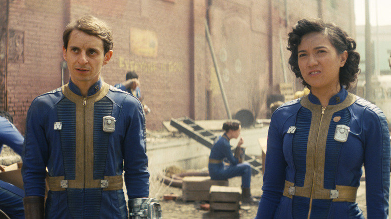 Norm and Claudia looking up while the rest of the Vault-dwellers struggle with life on the surface in Fallout