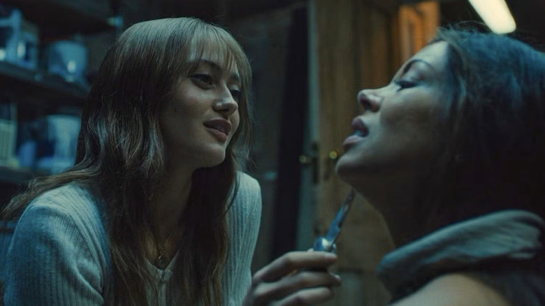 Rhiannon Lewis holding a knife to bound Julia's throat in Sweetpea