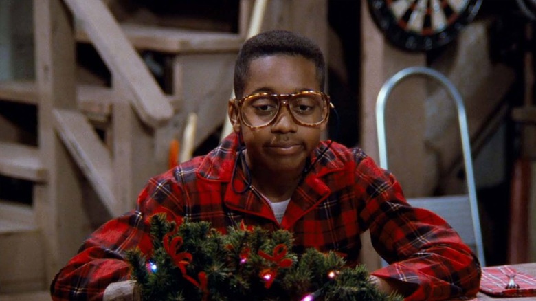 Steve Urkel sitting in front of a Christmas wreath looking dejected