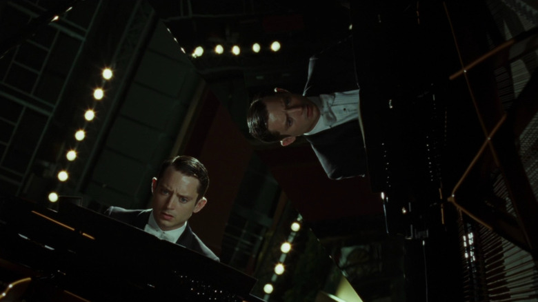 Elijah Wood as Tom Selznick seated at his piano (as shown by several angles) on the tail piano