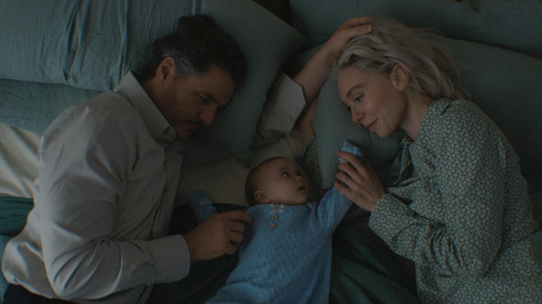 Pedro Pascal como Reed Richards/Mister Fantástico y Vanessa Kirby como Sue Storm/Mujer invisible yacía en la cama junto con Ada Scott como infante Franklin Richards en los Cuatro Fantásticos: Primeros Pasos