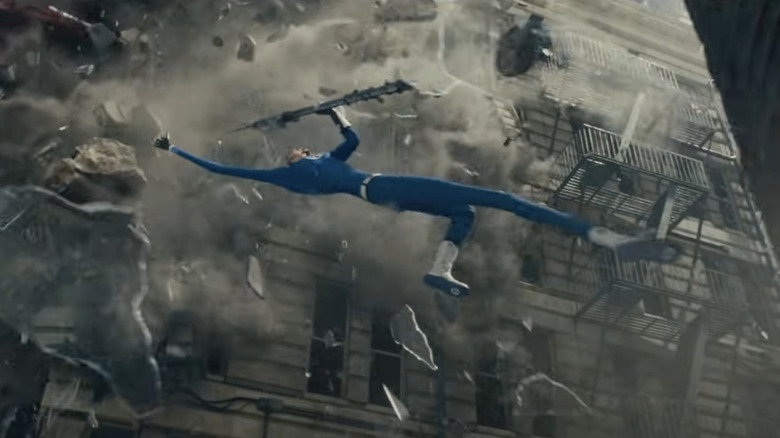 Pedro Pascal as Reed Richards stretches in front of a crumbling building in The Fantastic Four: First Steps