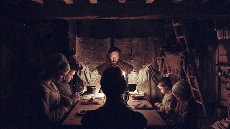 William, Jonas, Mercy, Katherine, Thomasin, and Caleb praying at their dinner table in The Witch