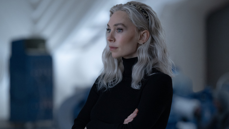 Vanessa Kirby como Sue Storm parada en el laboratorio en su suéter negro en los Fantásticos Cuatro: Primeros pasos