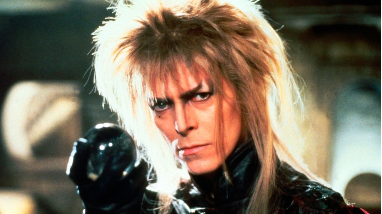 A man with long hair holding a crystal ball