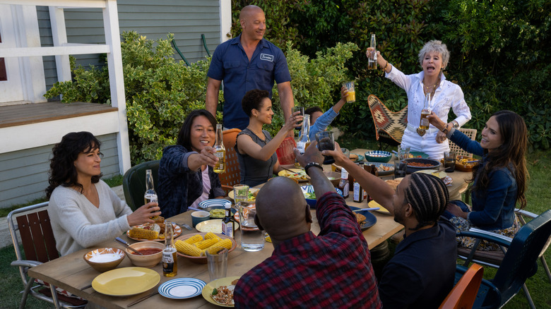 Vin Diesel as Dominic Toretto standing next to Rita Moreno as Abuelito as she raises a toast in front of Michelle Rodriguez as Letty, Sung Kang as Han, Nathalie Emmanuel as Ramsey, Leo Abelo Perry as Little Brian, Jordana Brewster as Mia, Ludacris as Tej, Tyrese Gibson as Roman in Fast X