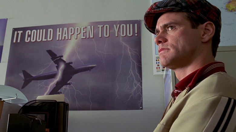 Jim Carrey in front of poster The Truman Show