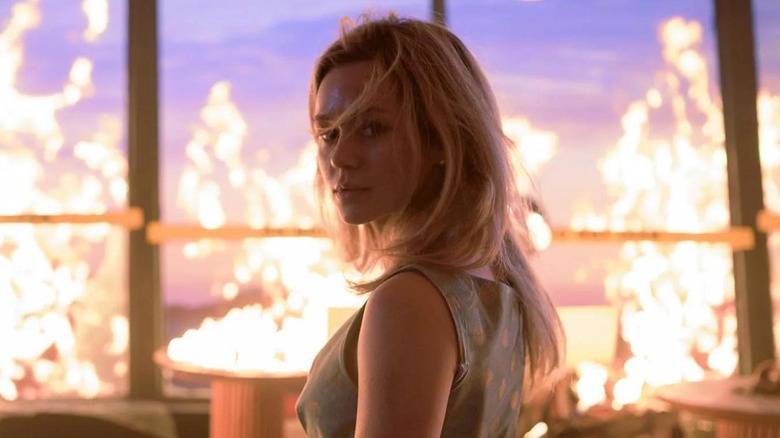 Brec Bassinger as Iris standing amongst the flames at the restaurant in Final Destination Bloodlines