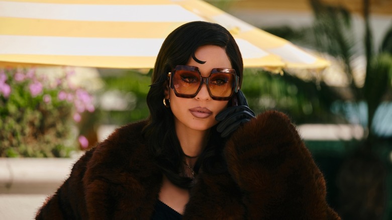 Maddy draagt ​​een zonnebril en een bontjas aan de telefoon op Euphoria