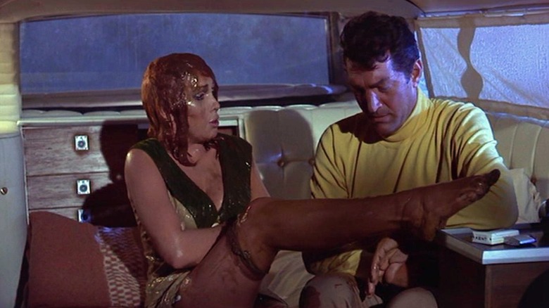 Matt Helm helping a very wet Gail in the back of a vehicle in The Silencers
