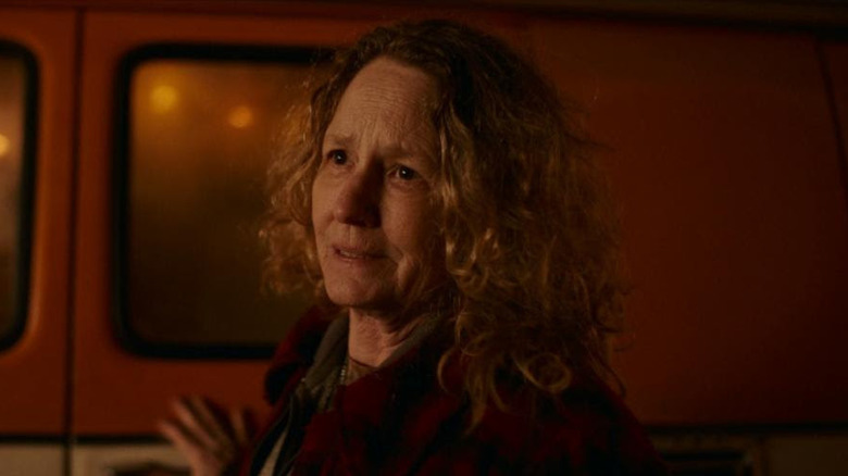 मेलिसा लिओ एक वृद्ध स्त्री म्हणून पॅसेंजरमध्ये वाहनाकडे झुकलेली