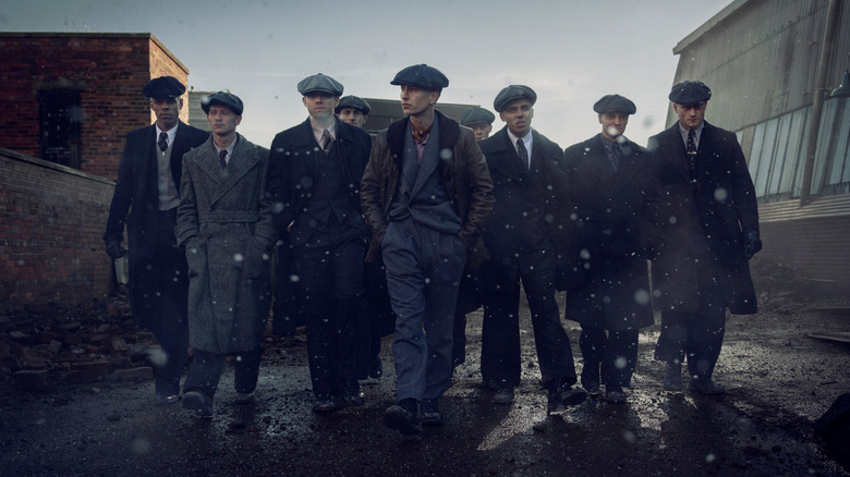 Barry Keoghan as a new character leading a pack of outlaws down a muddy street in Peaky Blinders: The Immortal Man