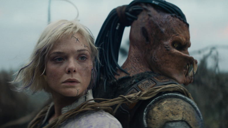 Thia, yang diikat di punggung Dek, menoleh bersamaan dengan kepalanya di Predator: Badlands